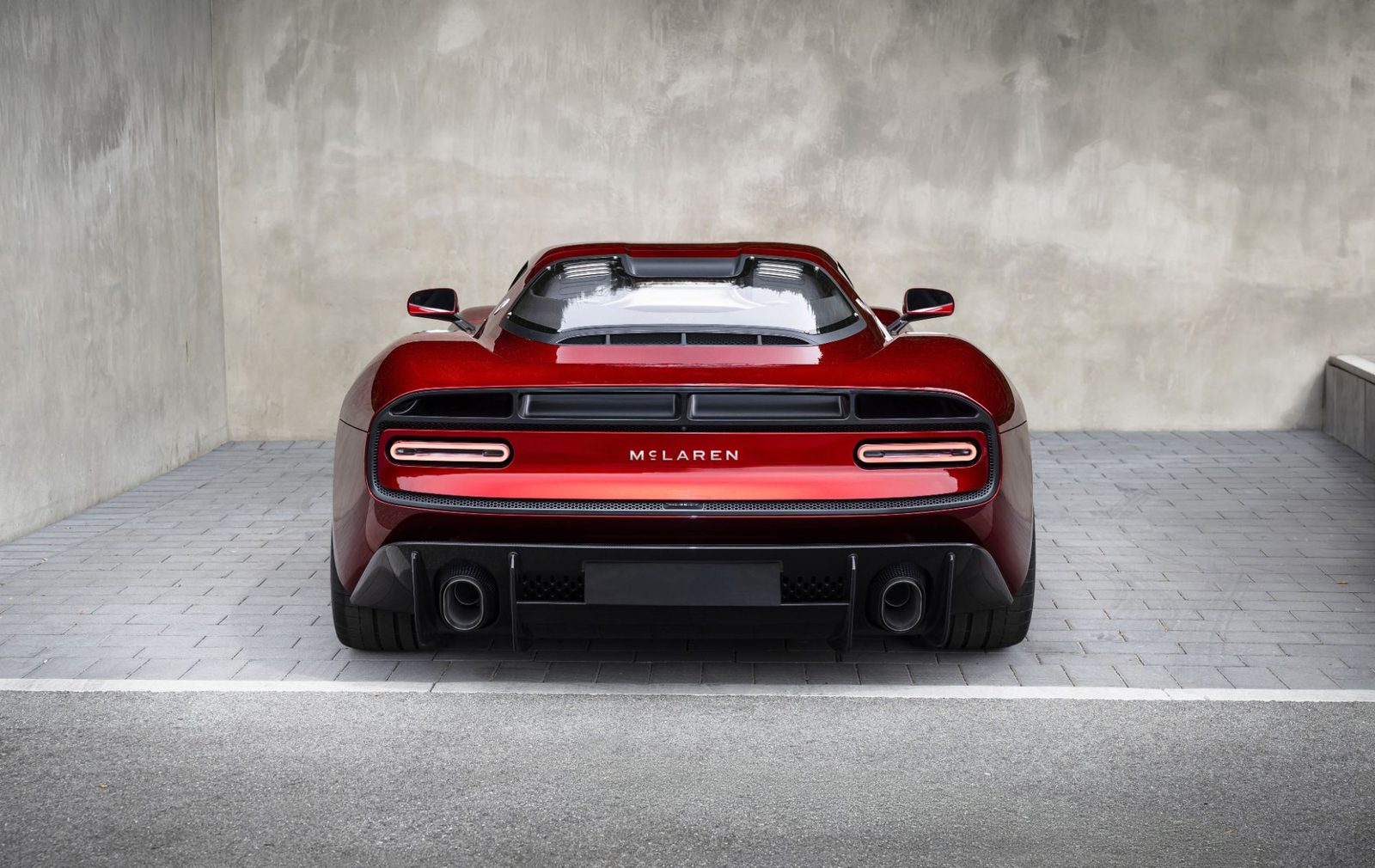 Rear view of a red McLaren road car with the new McLaren wordmark between the tail lights